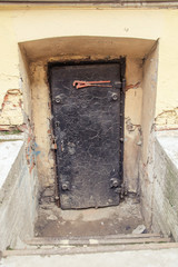 the old, black door after the stairs to the basement