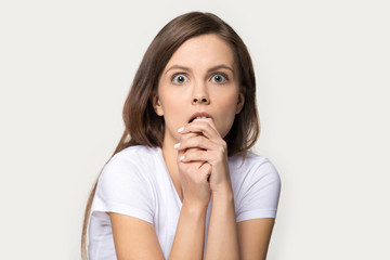 Headshot of frightened woman looking at fear eyes wide open