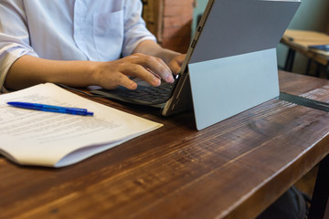 Close up of human hands typing on digital notebook