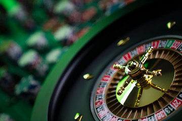Casino theme, close up of roulette, red and black numbers. Stack of chips in the background.