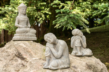 three stone buddha statues on top of a rock
