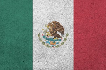 Mexico flag depicted in bright paint colors on old relief plastering wall. Textured banner on rough...