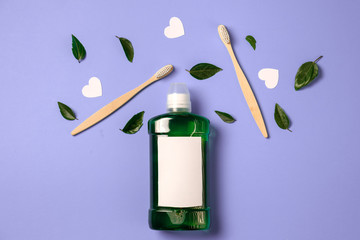 Mouthwash, two wooden bamboo eco friendly toothbrushes, green leaf, white hearts on purple background. Teeth hygiene, valentines day concept. Flat lay, copy space