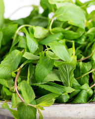 Mint. Bunch of Fresh green organic mint leaf in bowl on wooden table closeup
