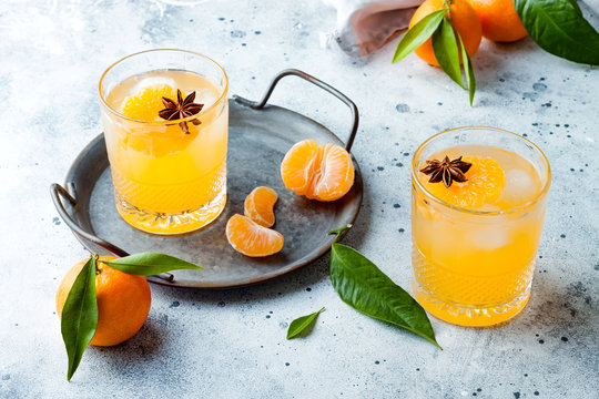 Spicy Winter Yellow Orange Cocktail Or Mocktail With Fresh Tangerines And Anise On Grey Background. Christmas And New Year Holiday Welcome Drink, Copy Space