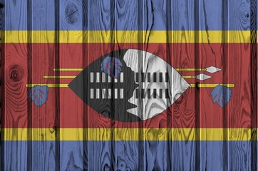 Swaziland flag depicted in bright paint colors on old wooden wall. Textured banner on rough...