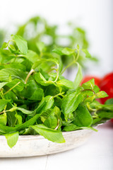 Mint. Bunch of Fresh green organic mint leaf in bowl on wooden table closeup  