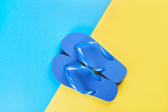 Blue flip-flops over a yellow-blue background