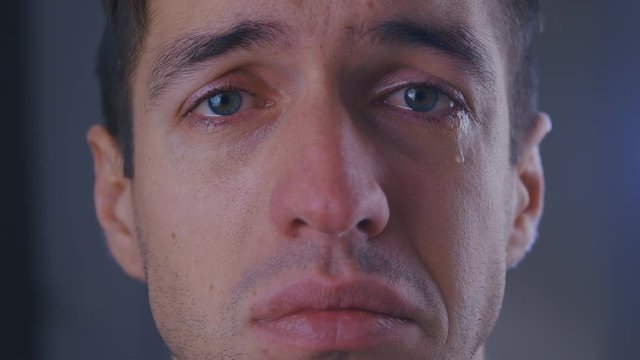 Close-up face of sad man crying with tears in eyes