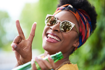 Attractive young african american woman having a drink listening