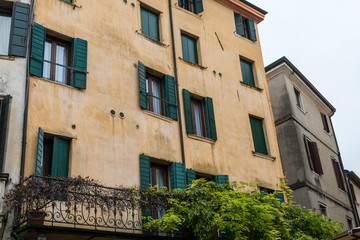 Fototapeta na wymiar gelbe Hausfassade mit grünen Fensterläden