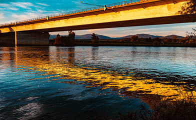 Beautiful sunset with a bridge and reflections near Mettenufer, Danube, Bavaria, Germany
