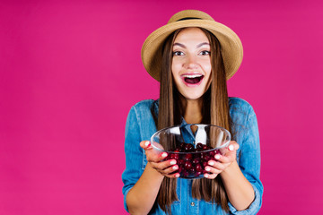 the girl the summer resident joyfully laughs showing people the harvest of cherries in a vase that holds