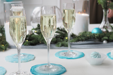 glasses of champagne on the festive table decorated for the new year in delicate blue and white colors