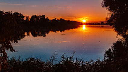 Beautiful sunset with reflections near Mettenufer, Danube, Bavaria, Germany