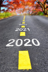 New year 2020 to 2023 on asphalt road surface with autumn season background