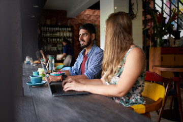 Couple smiling together sitting at table and discussinga small b