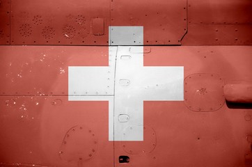 Switzerland flag depicted on side part of military armored helicopter closeup. Army forces aircraft...