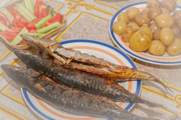 Smoked mackerel cooked on a plate laid for dinner table