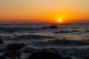 orange red sunrise at the wavy beach