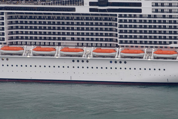 Detalle de un barco crucero de recreo con ventanas de habitaciones y botes salvavidas