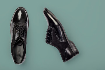 Black female patent shoes on dark green background. Fashion flat lay