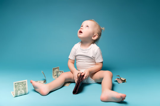 little girl looks up holding mother's wallet in her hands. Around scattered dollars