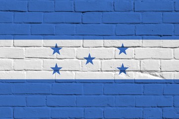 Honduras flag depicted in paint colors on old brick wall. Textured banner on big brick wall masonry...