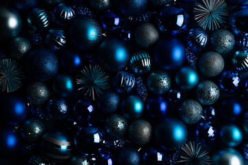 Christmas, New Year blue background in low key. Monochrome christmas balls and decor.