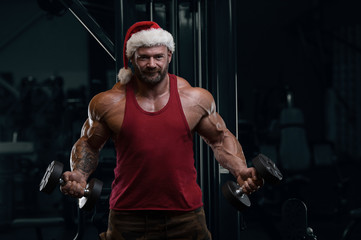 Bodybuilder in Santa Claus costume in the gym