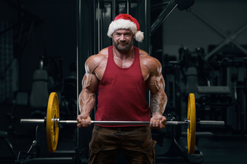 Bodybuilder in Santa Claus costume in the gym