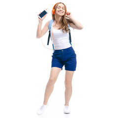 Woman in blue shorts and white shirt with blue backpack student dancing happiness, listening to music on headphones, smartphone on white background isolation