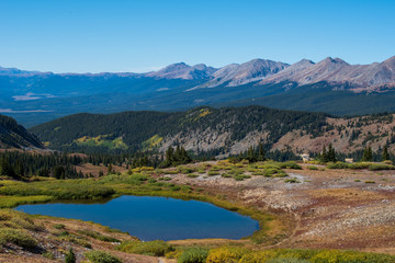 Naklejka na ściany i meble Landscape of small pond, trees and mountain tops at Cottonwood Pass in Colorado