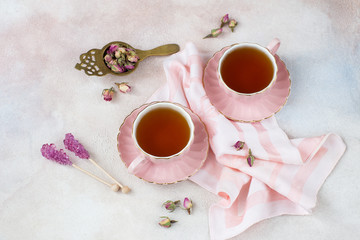 Obraz na płótnie Canvas rose tea in pink cups, rose buds and pink sugar