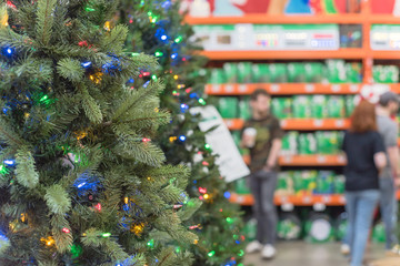 Shallow DOF customer shopping for artificial Xmas at hardware store in USA