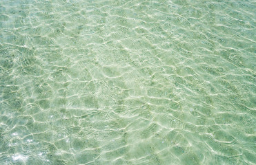 shallow crystal clear water in the tropical sea, ripples and reflections. texture as background