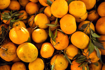 A lot of fresh yellow mandarin in the market, fruit background