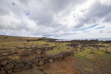 Remains of stone structures and the toppled moai Te Pito Kura along the northern coast of Easter...