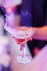 The bride holds a glass with champagne in her hand. Close-up shot of hands, tossing glass of alcohol at a party or event.