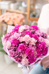 Violet and pink color two mono bouquets of carnation in womans hands. European floral shop. the...