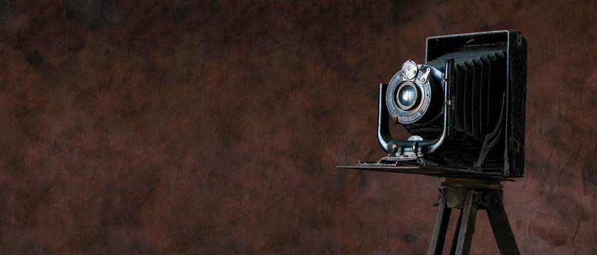 old camera on vintage background - Powered by Adobe