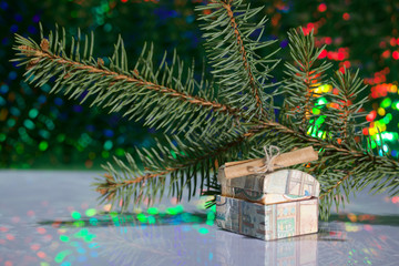 Open chest with gifts. A folded note is enclosed in it. Against the background of a fir branch and rainbow bokeh.