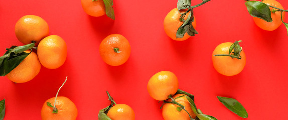 Orange tangerine with leaves on an red background