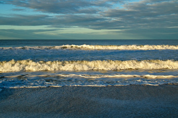 Large cresting waves on bonita beach at the gulf of mexico in bonita springs florida at sunrise.