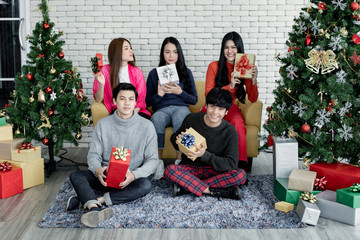 Group young Asian with gifts at home in celebrating Christmas festival.