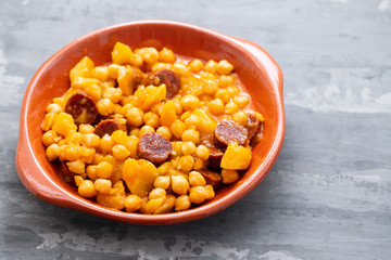 chickpea with potato and smoked sausage on ceramic dish