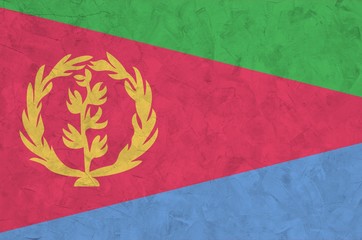 Eritrea flag depicted in bright paint colors on old relief plastering wall. Textured banner on...