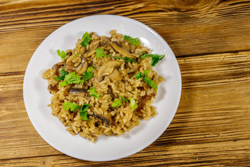 Tasty risotto with mushrooms on wooden table. Top view