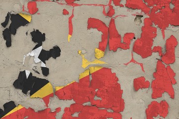Timor Leste flag depicted in paint colors on old obsolete messy concrete wall closeup. Textured...