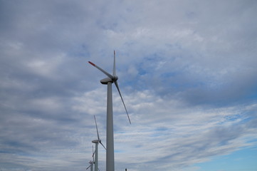 Wind turbines spin on a cloudy day